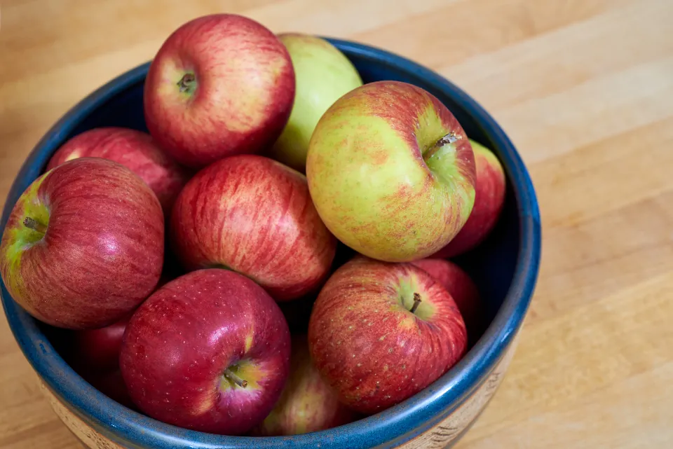 Cuenco de cerámica lleno de manzanas rojas