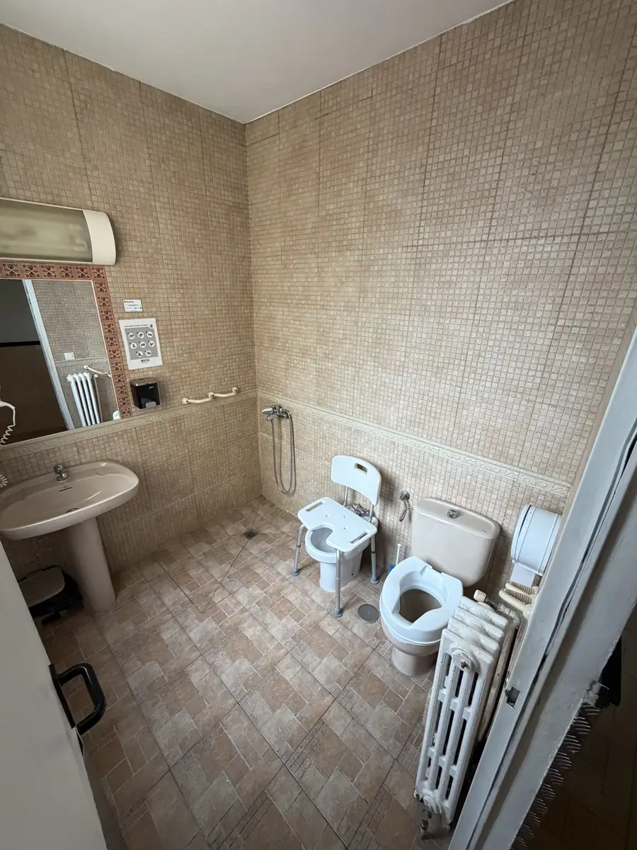Baño amplio con lavabo, inodoro y asideros