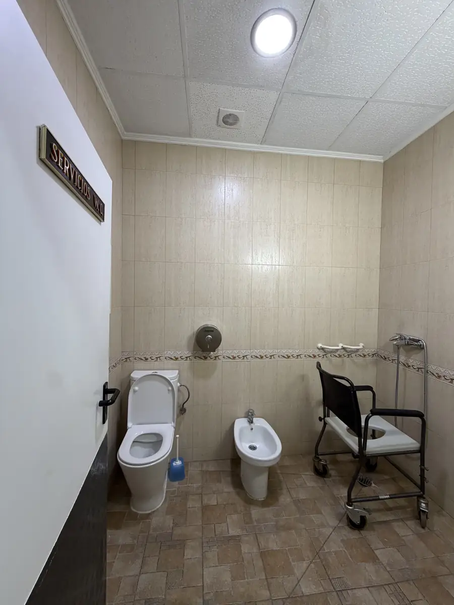 Baño con inodoro, bidé y silla de ducha