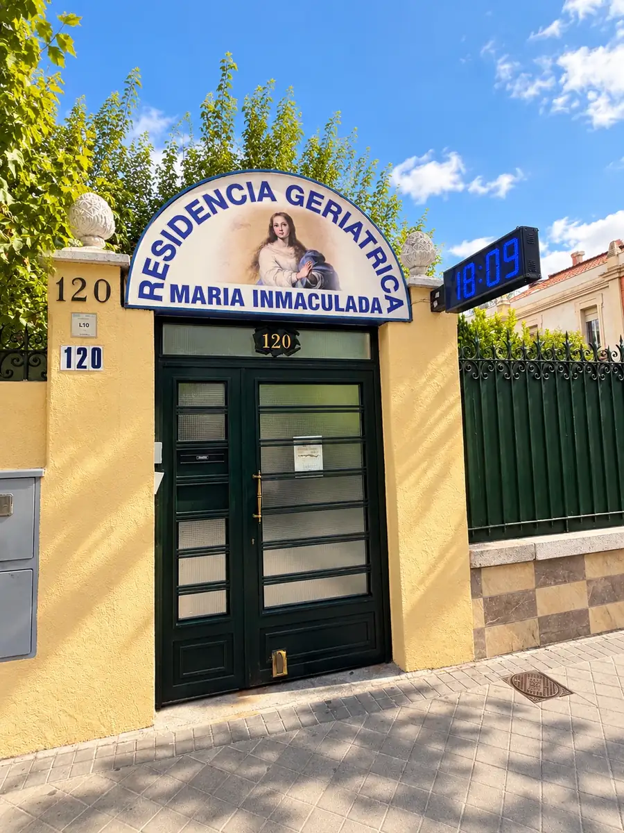 Puerta de entrada con el número 120 y el cartel con la Virgen