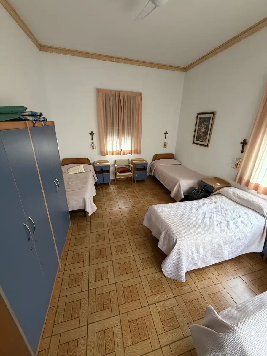Habitación con tres camas, armario y ventana