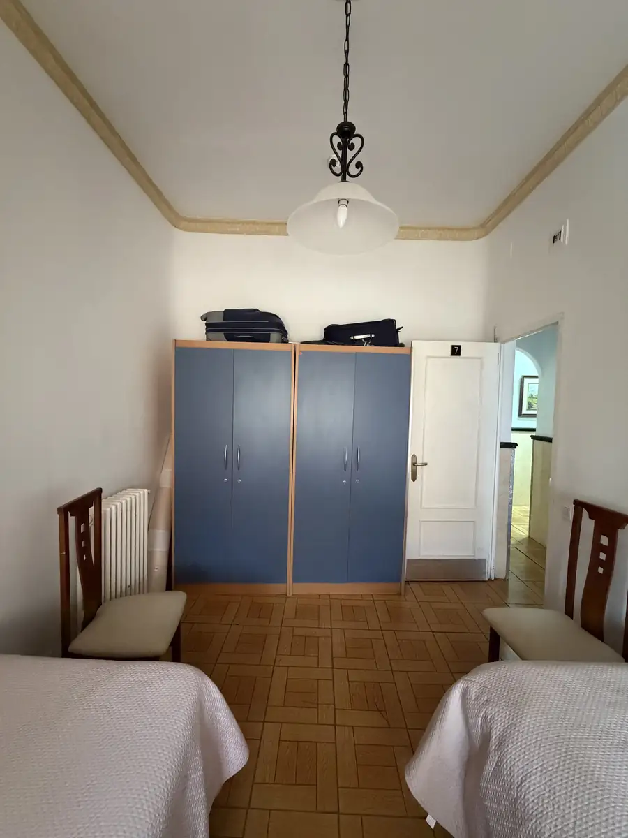 Habitación con dos camas, armario doble y lámpara