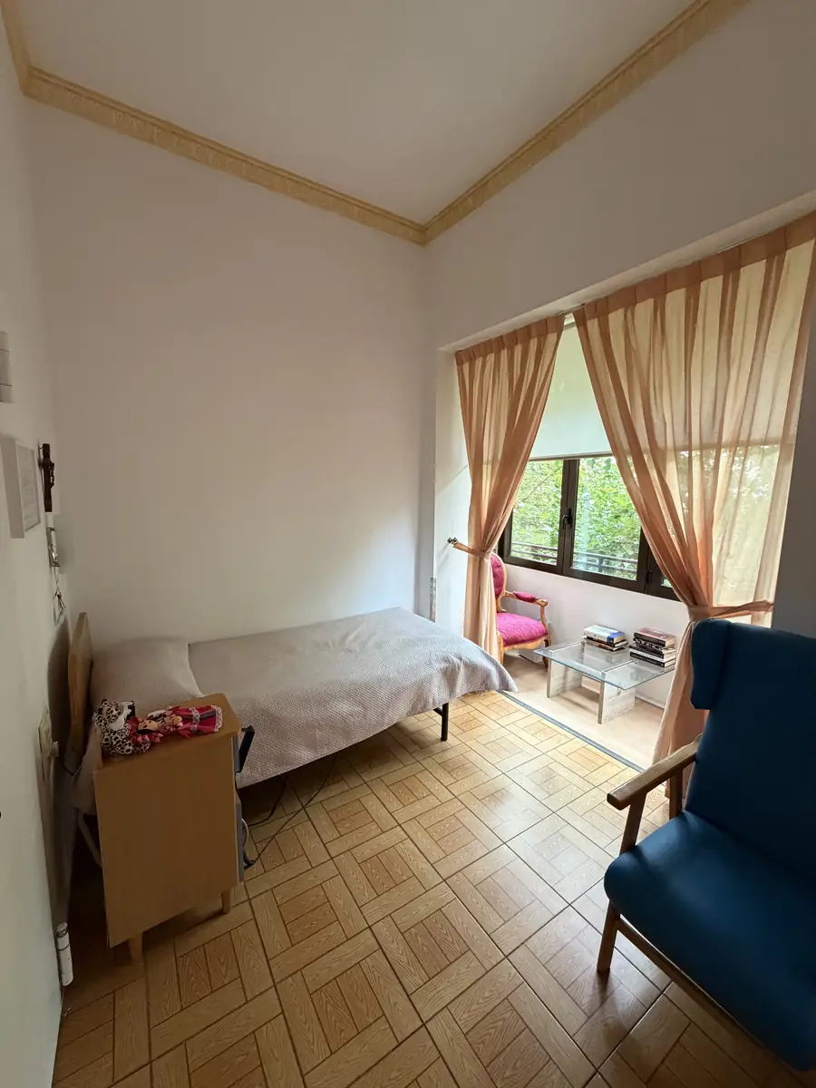 Habitación con cama, butaca y ventanal