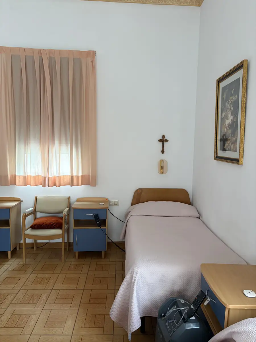 Habitación con cama, mesillas, silla y cuadro