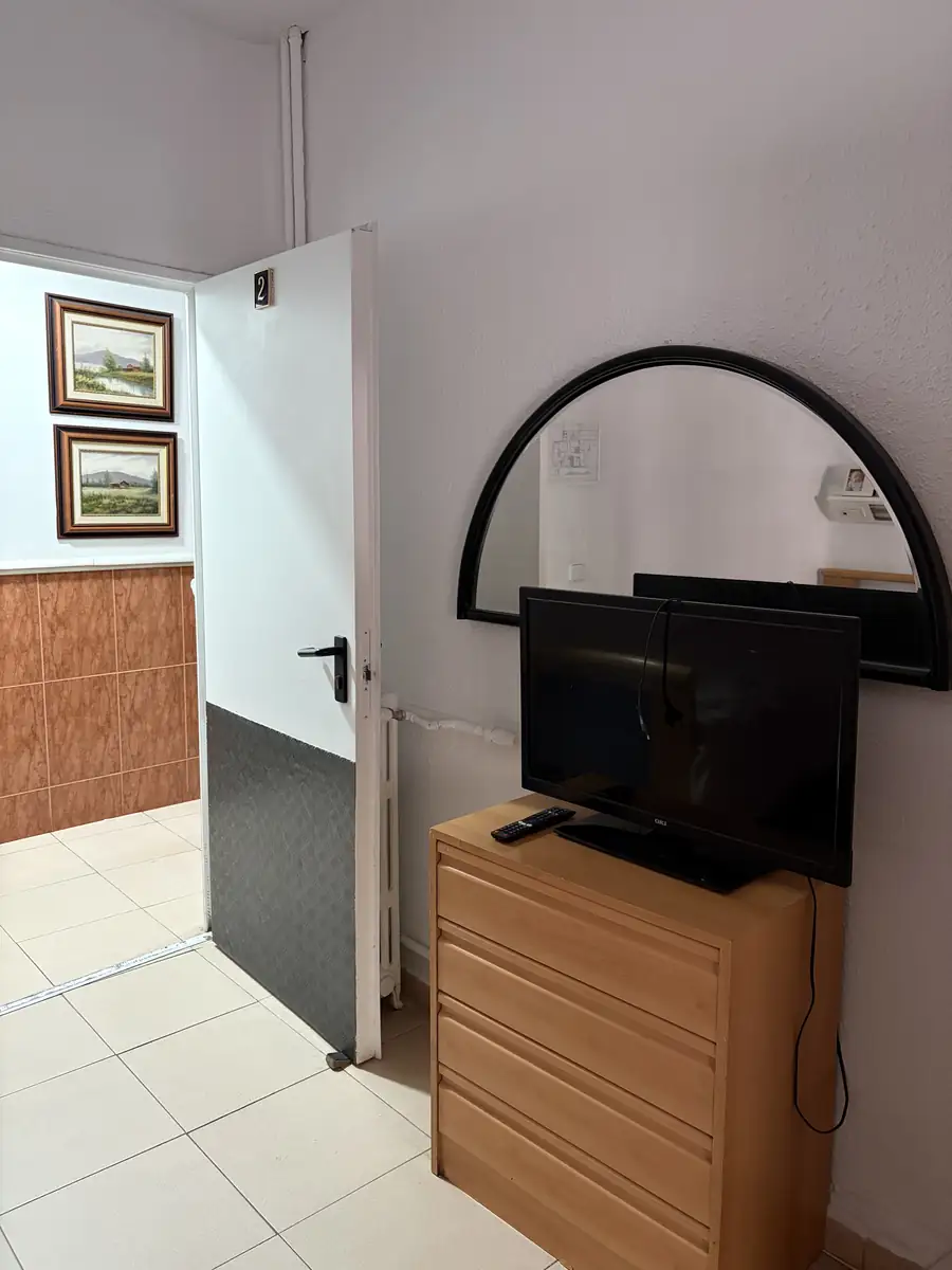 Cómoda con televisión y espejo en una habitación