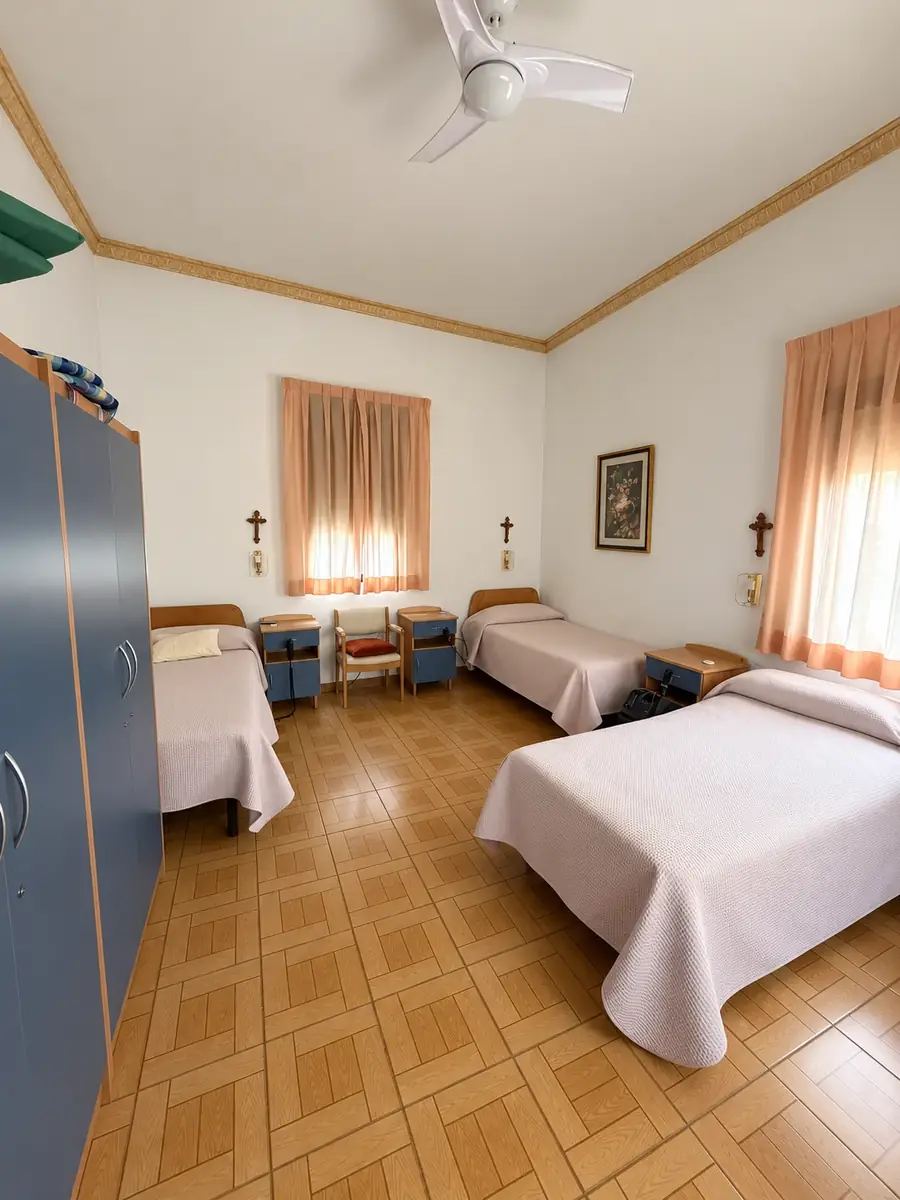 Habitación amplia con camas, armario, ventilador de techo y dos ventanas