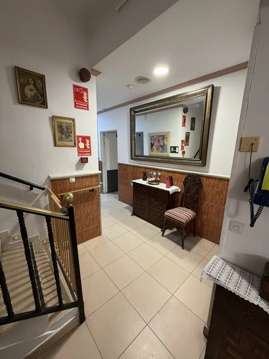 Pasillo con espejo, cómoda, cuadros y barandilla