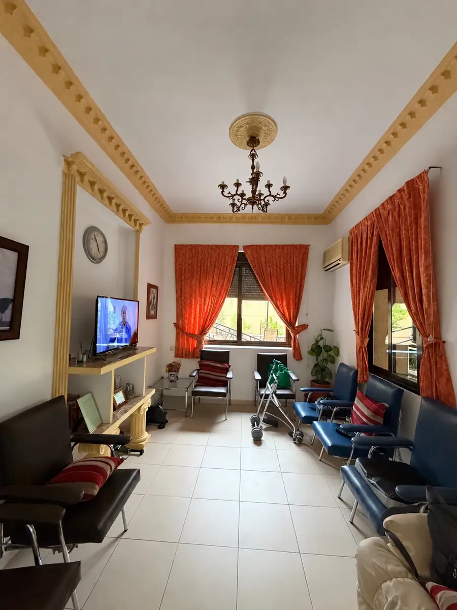 Salita con butacas, televisión y cortinas naranjas