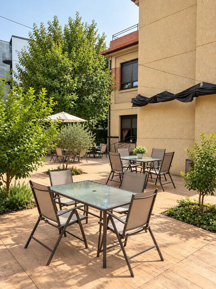 Mesas y sillas en la terraza junto a pequeños árboles